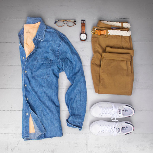 A blue chambray shirt with a salmon T-shirt, light tan chinos and white trainers