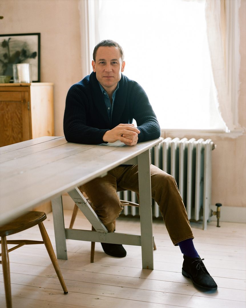 The chambray shirt worn with a navy cardigan and light tan chinos